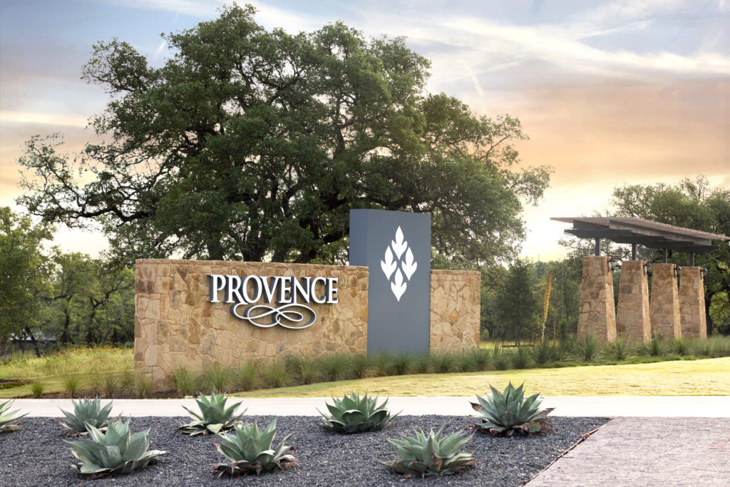 Provence community entry sign with xeriscaped garden at sunset.